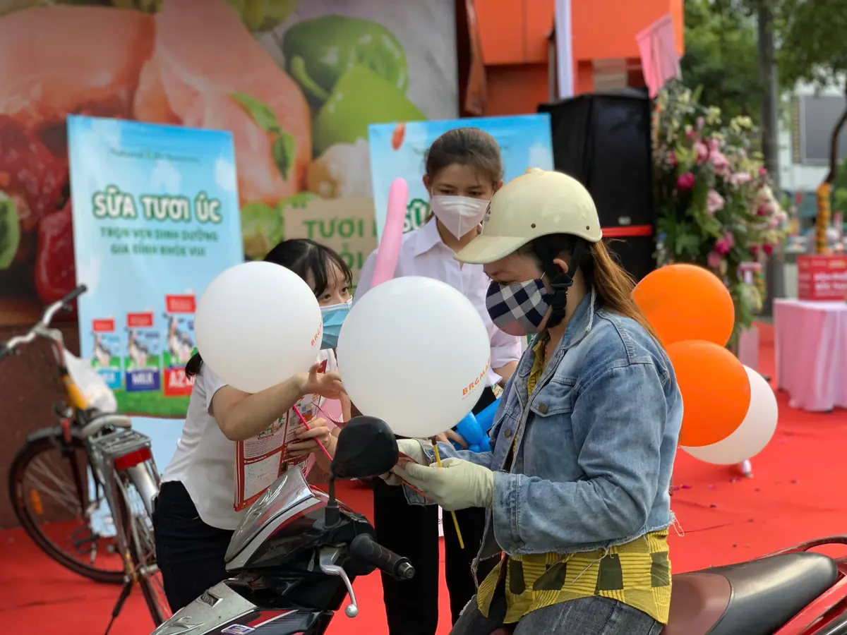 PG phát bong bóng và tờ rơi cho người đi xe máy trước siêu thị ngày khai trương