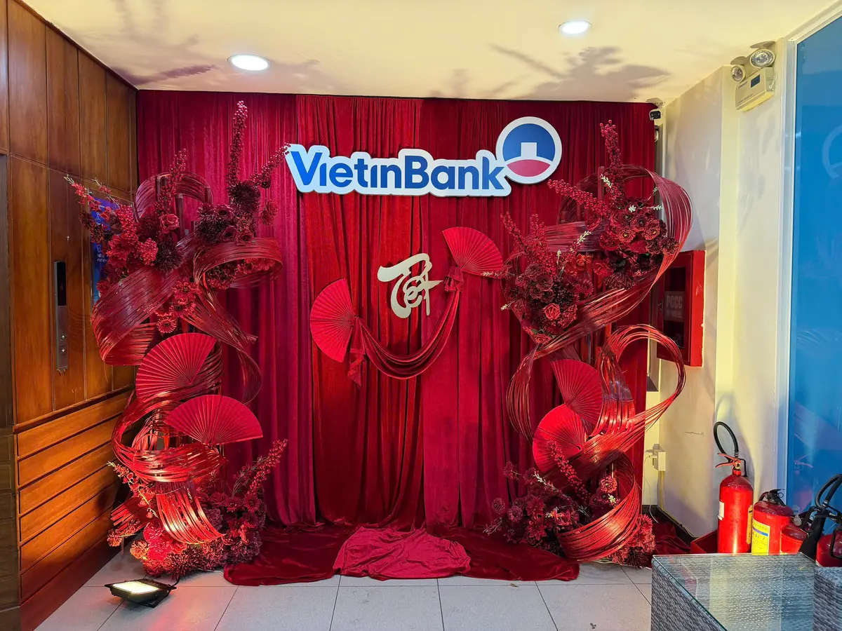 Mảng trang trí hoa đỏ và quạt quanh logo thương hiệu