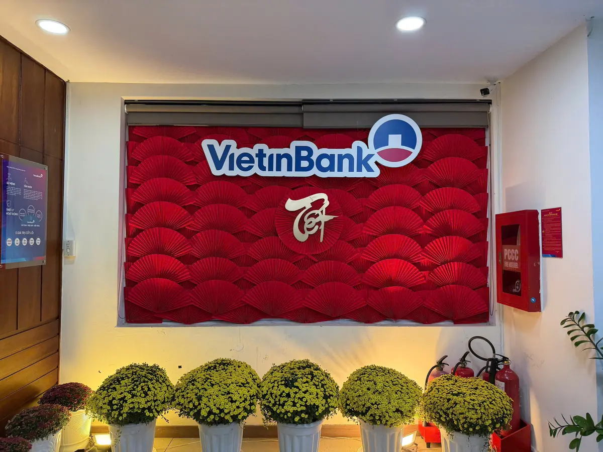 Tường quạt đỏ in chữ Tết và hàng chậu cúc