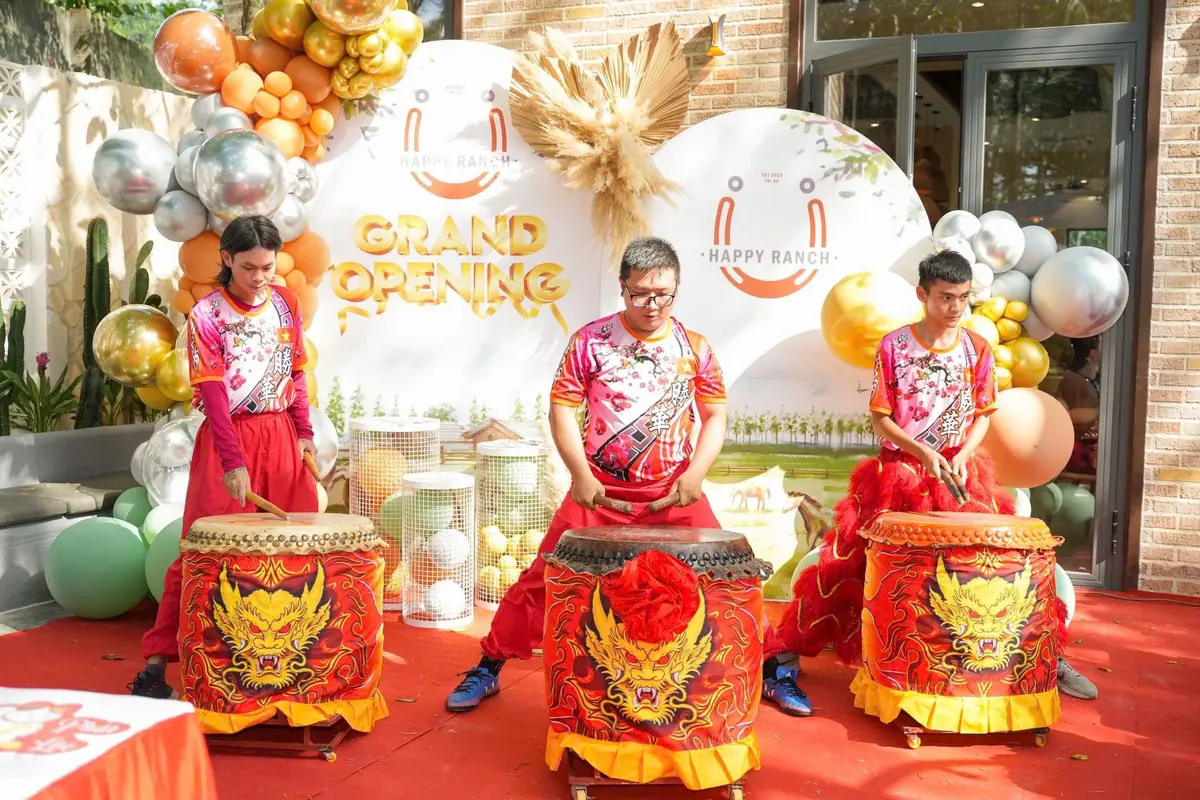 Ba tay trống đánh trống lân trước backdrop khai trương